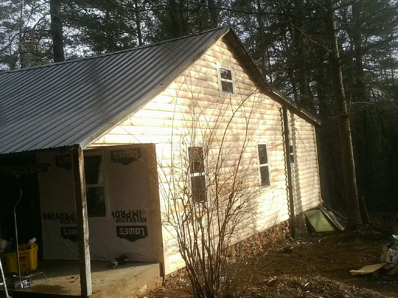 Log siding gable end under a dark metal roof edge in Lone Tree