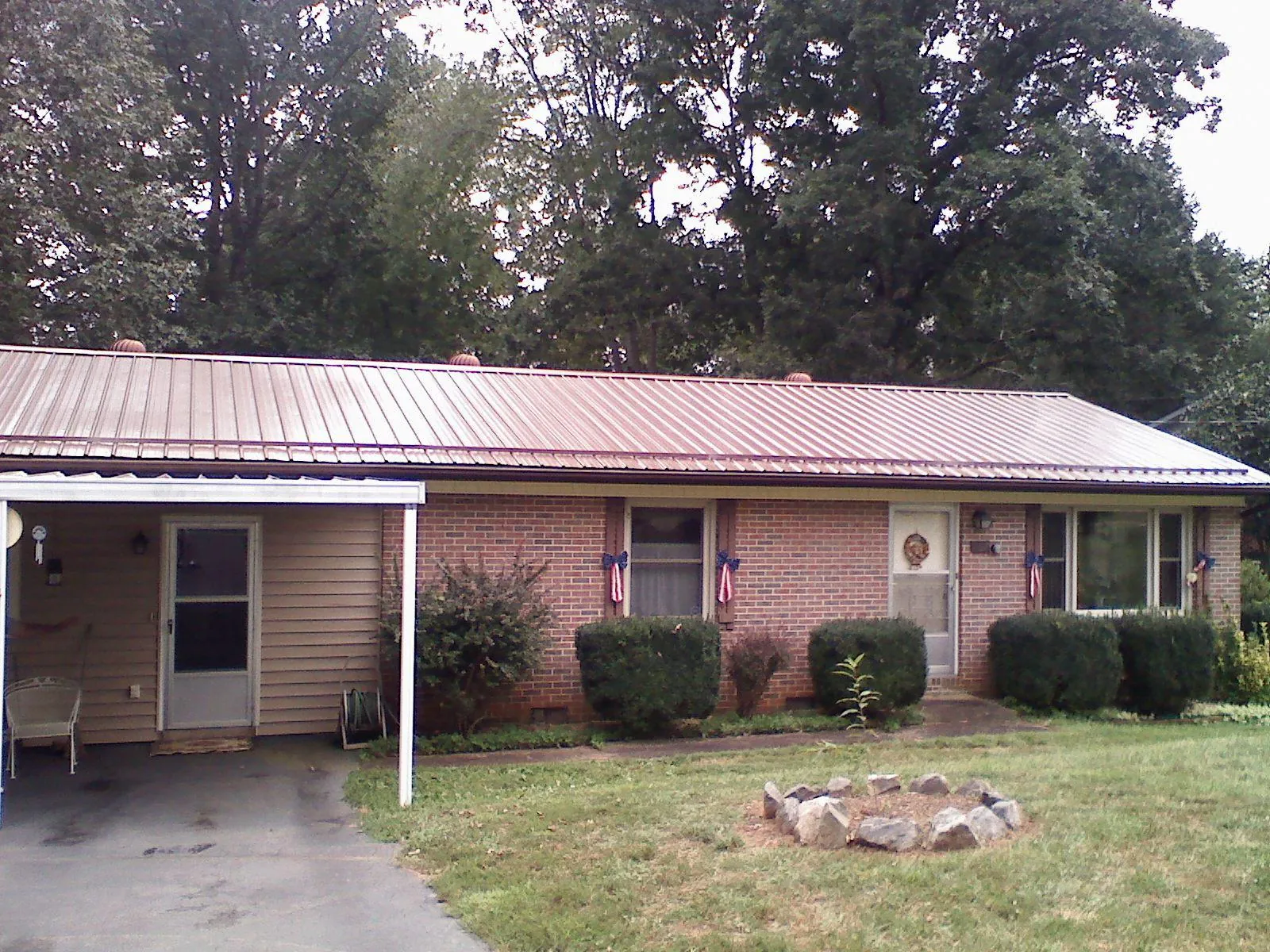 Bronze metal roof and carport on a brick ranch home — Roof Repair work by our crew in Lone Tree